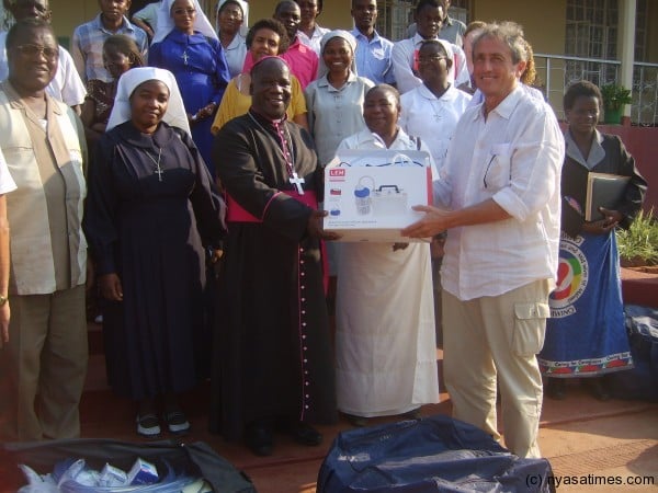  Bishop Msusa receives the symbolic donation from a representative from Clara Foundation