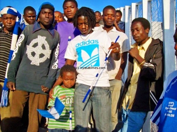 Kamwendo with his son posing with Nomads fans