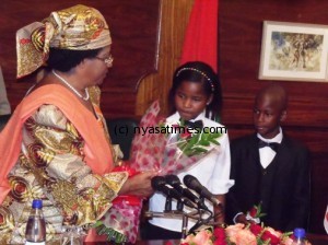 Young Red Cross members gives flowers to their Patron