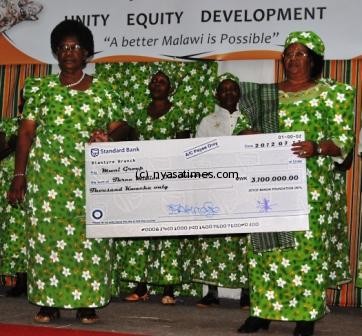 President Mrs. Joyce Banda presenting a K 3.1Million cheque to Mwai group during her 100 days of presidency at Comesa hall in Bt.Pic Francis Mphweya.