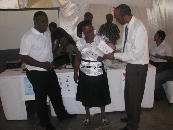 Osman (R) explains his presentation to one of the participants (c) while Paul Nsikula looks on