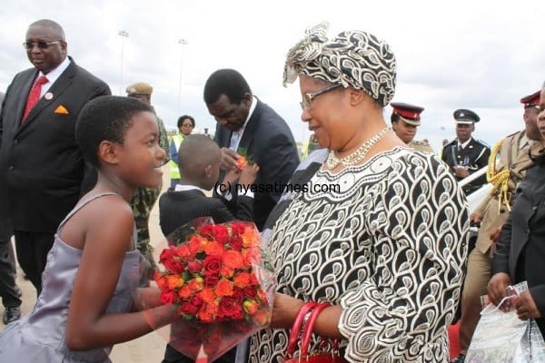 A 10 year old girl welcomes the Malawi leader with flowers at KIA from Nigeria-pic by Lisa Vintulla.