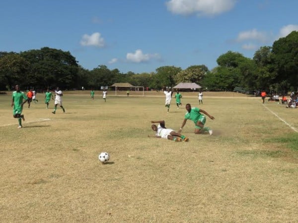 A Cobbe player is tackled from behind by a Moyale player in football