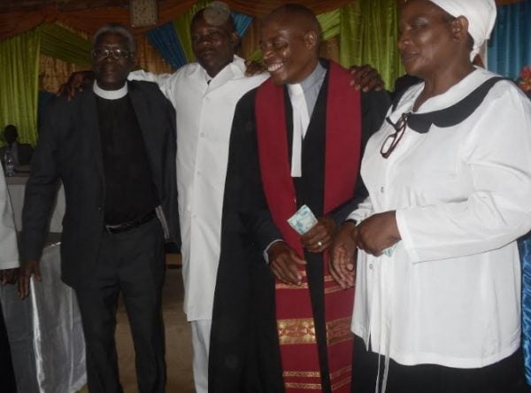 Rev.Mdoka Chirambo in red robe celebrates induction ceremony of Willard Phiri in white robe along side the Reverend Kawale and his decons at Mzuzu police Prayer House