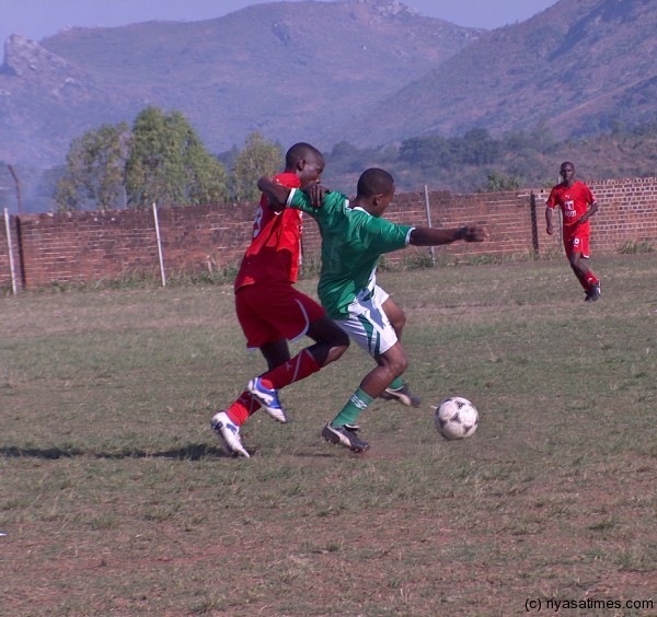 A Red Lions player (in red) and a Green Hawks player fight for the ball during the game