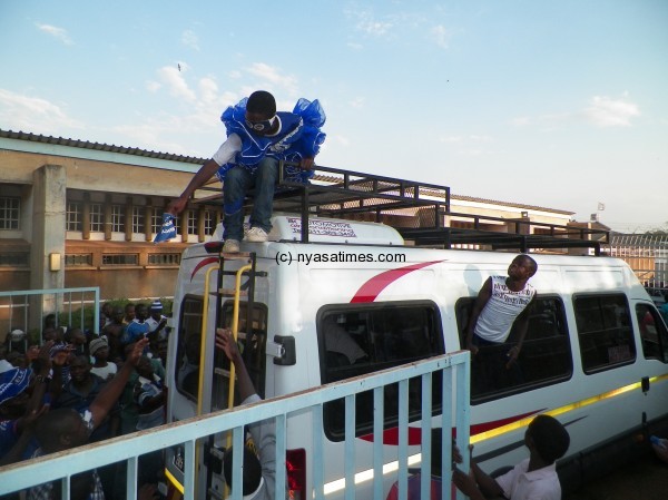 A Wanderers' fan gets on top of KB's bus after the game, below a KB player tells the fan to get off the bus, Pic Leonard Sharra, Nyasa Times