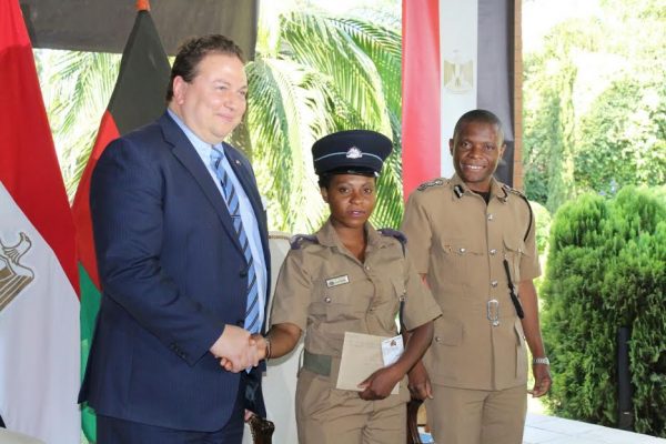 A female police officer poses with the Egyptian enviy after receiving her ticket as Chipao looks on