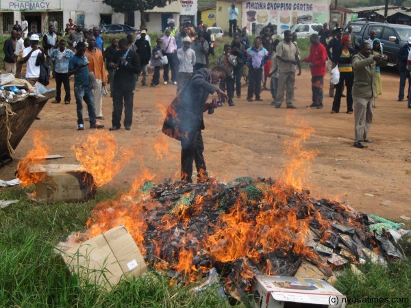 A member of PHOTAMA taking a close-up photograph of the burning of  pirated materials