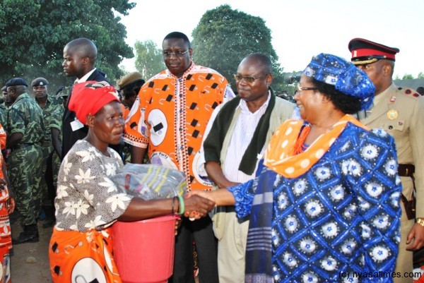 A recepient of relief items greets the President