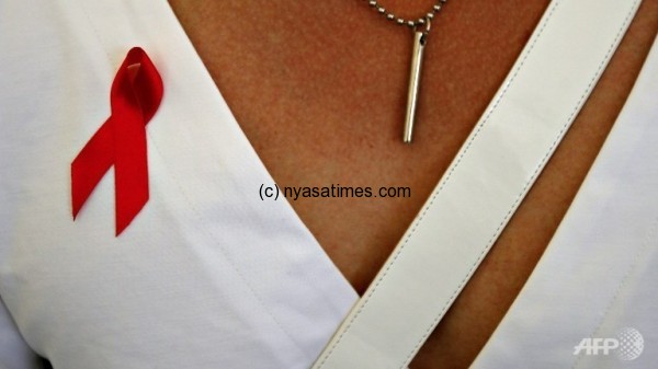 A woman wearing an AIDS ribbon