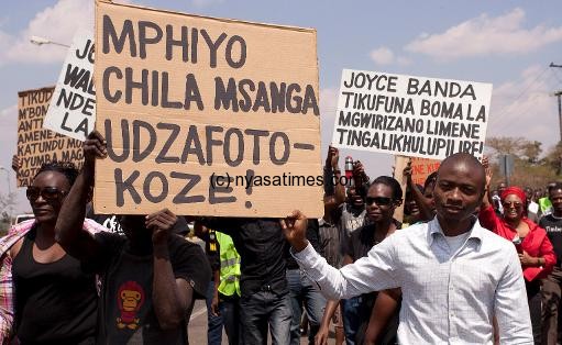 Protesters in Lilongwe on October 10, 2013, hold placards wishing Paul Mphwiyo a quick recovery (Photo- Amos Gumulira, AFP)