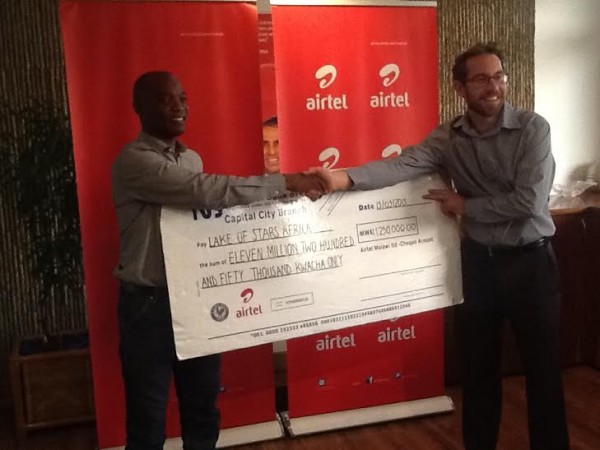 Airtel Malawi Chief Commercial officer Charles Kamoto handover the dummy cheque to Founder of Lake of Stars Will Jameson