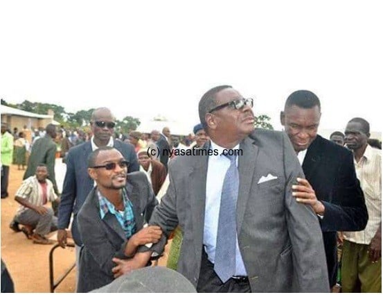 Mutharika being protected from a swarm of bees during voting day May 2014