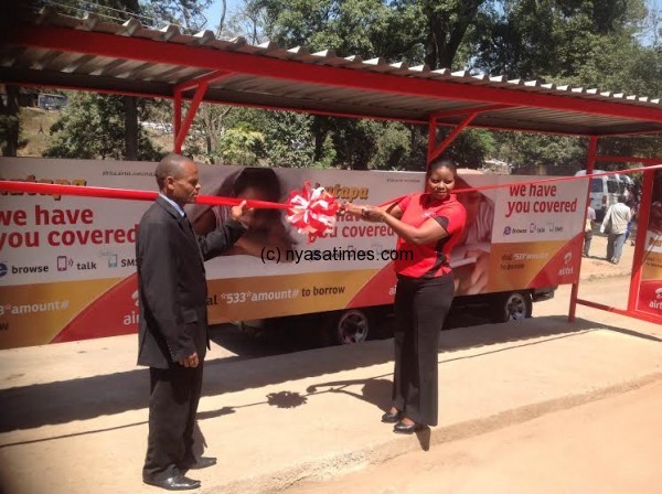 Airtel's Mijiga hands over the bus shelter to MOAM's Kamange.