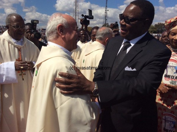 Mutharika and one of the Catholic clerics during Amecea