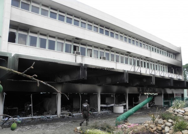 An ESCOM security guard passes through the ruins