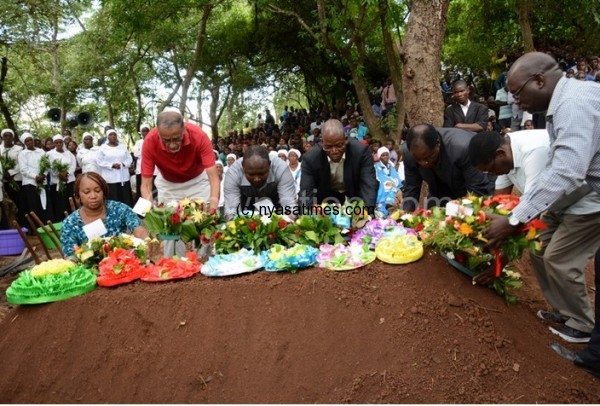 NPL CEO Mbumba Banda (extreme left) leads a group media practitioners in laying wreaths on Chitsulo's grave.- Photo by NPL