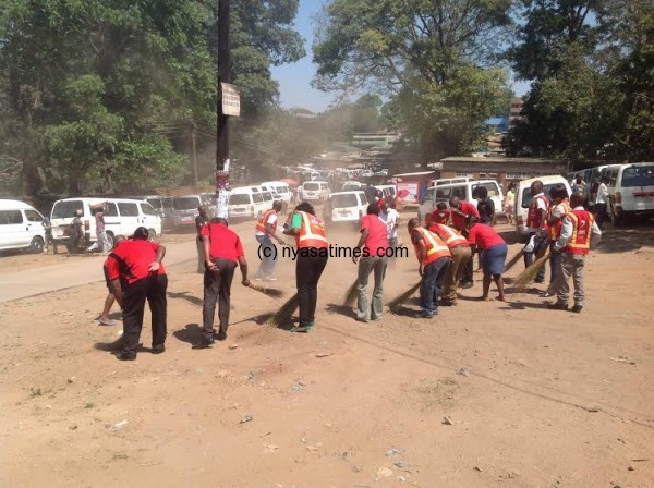  the broom invasion: airtel staff in a sweeping exercise at Mibawa before the handover of the shelter.