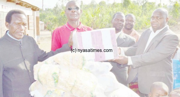 Times editorial boss Ligomeka presenting the donated items to Bishop Mbewe