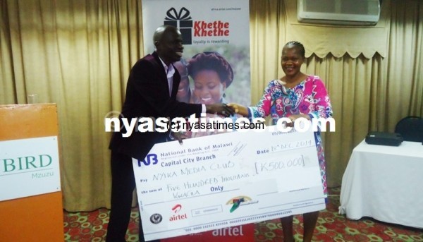 Msimuko receiving a cheque from Airtel Malawi's Tsilizani