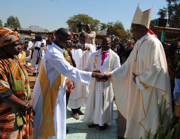 Bishop Emmanuel Kanyama welcoming his new priest as the mother to the ordained looks on.....Photo Jeromy Kadewere