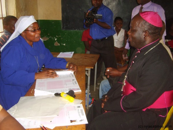 Bishop Msusa (right) registering at Sacred Heart Primary School centre in Zomba