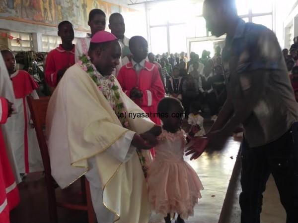 Bishop Stima interracts with a child.