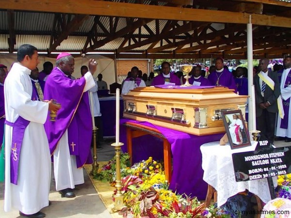 Bishop Zuza  blessing the casket with holy water....Photo Jeromy Kadewere