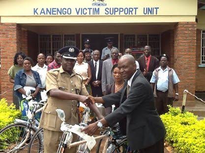 Bisnowaty Personal Assistant, Mark Zilirakhasu, handingover the bicycles to Kanengo Police Officer in Charge