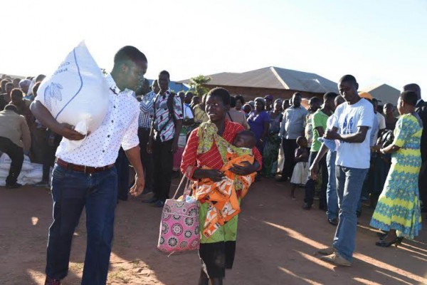 Bushiri carrying the maize bag for a mother 
