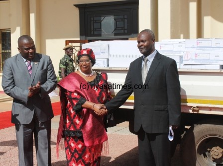 Chimwemwe Chikusa Country manager for RAKGAS International Limited shakes hands with President Joyce Banda after donating medical supplies at Kamuzu Palace-pic by Stanly Makuti.