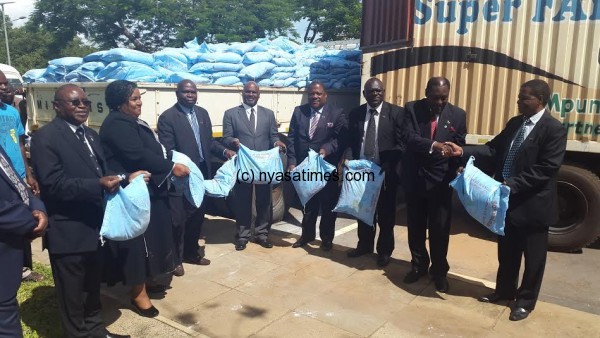 Cabinet ministers display bags of maize flour they have donated