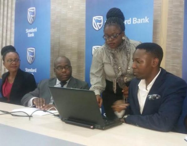 Capital FM's Elita Nkalo conducting a draw whil Kazima and other Standard Bank Officials look on.
