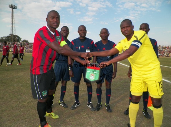 Captains for the two teams display a golden jubilee flag for Malawi