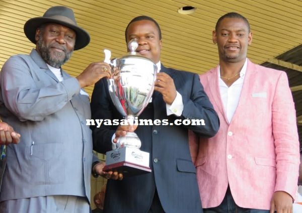 Carlsberg's Tikwale Chirwa handing the cup to Sports Minister Henry Mussa..Photo Jeromy Kadewere