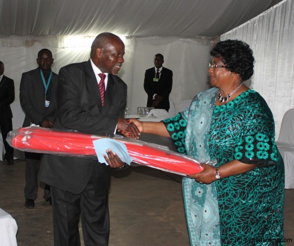 Chairperson of Chewa Heritage Proff George Kanyama Phiri presents a gift of Chewa cloth to President Joyce Banda at the fundrasing dinner at Capital Hotel-pic by Lisa Vintulla