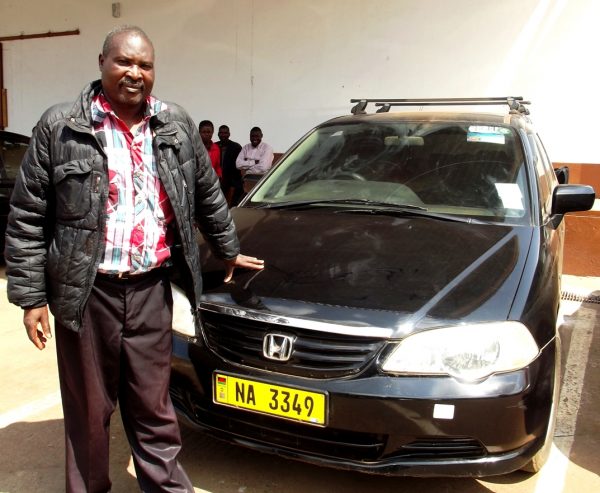 Chazama - Proud beneficiary of 2016 tobacco season stands next to his Honda-make vehical