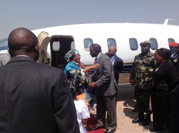 Cheif Justice Richard Banda RTD hugs President Banda as she alights from the plane