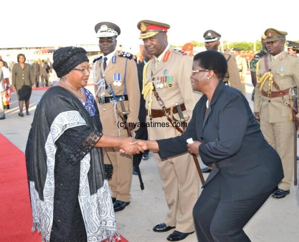 Women in black on Monday attire: Chief secretary to the Government Hawa Ndilowe bids farewel to President  Joyce Banda at Kamuzu International Airport on her way to pay last respects to Nelson Mandela in South Africa