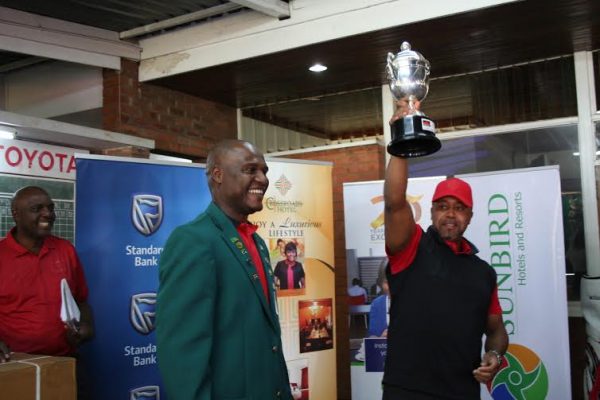 Chilima raises the trophy after being presented by Frank Mvalo, President of Golf Union of Malawi and Charles Mvula, Lilongwe Golf Club captain (left)