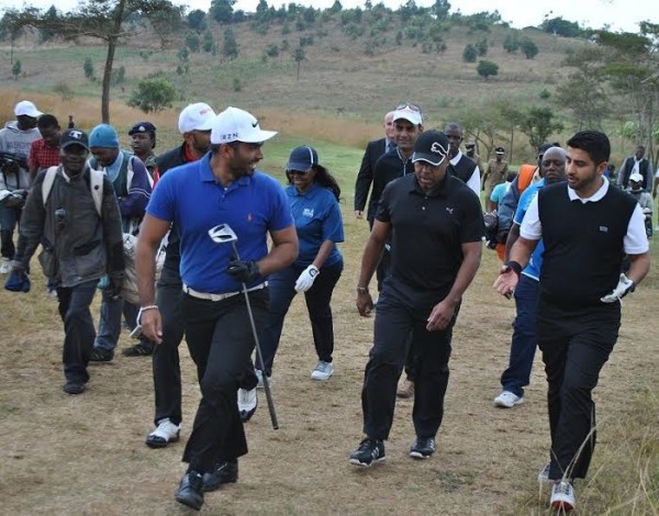Chilima walking about with other golfers playing the game