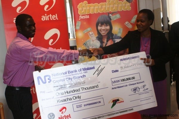 Chimtele receiving his prize from Airtel's Edith Tsilizani
