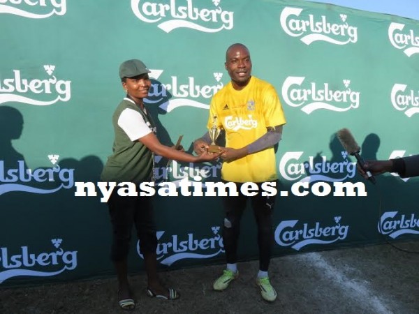 Chipuwa gets his man-of-the-match award from a Carlsberg lady