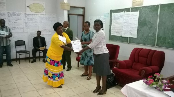 DC Memory Kaleso presenting a certificate to one of the care givers as Bottoman (C) looks on