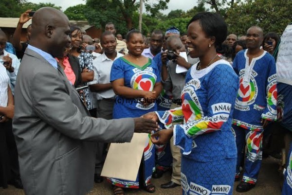 Distrcit Commisioner for Lilongwe Felix Mkandawire receives the petition from Harriet Kapyepye of NONM