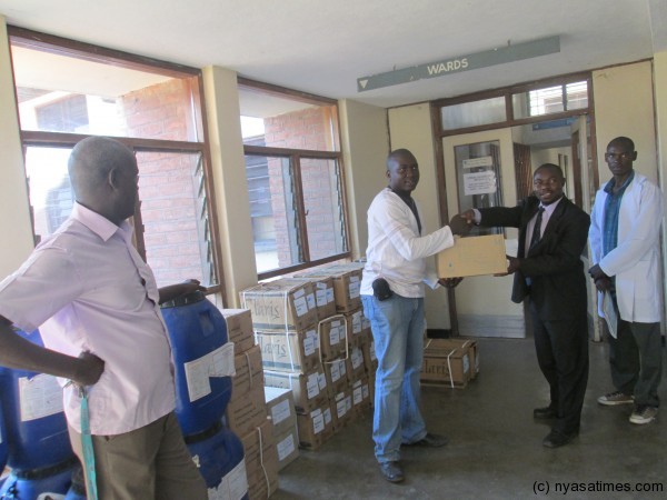 District Health Officer Michael Kayange (right) receiving  from Programme Manager Cornex Mbaluko
