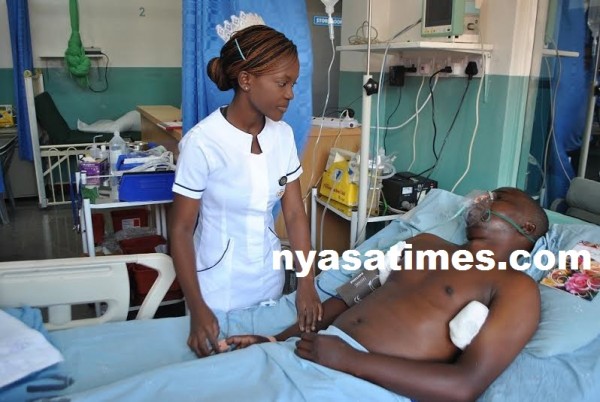 A nurse Doreen Mvula assisting Godffrey who is still unconscious