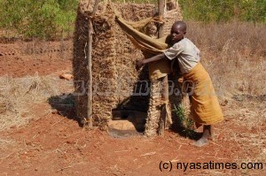 A girl showing a pit latrine