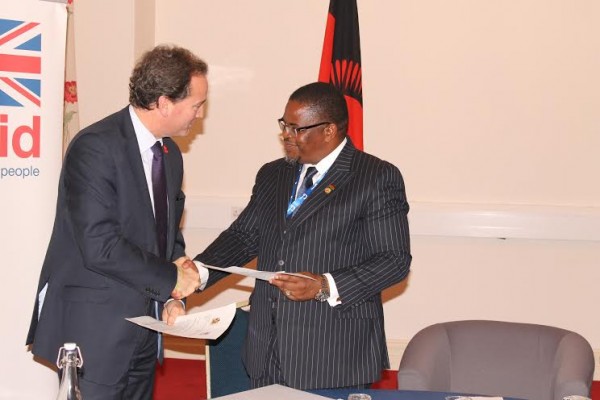 Energy Minister Bright Msaka and Hurd Exchanging documents.