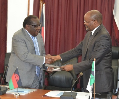 Finance Minister Goodall Gondwe exchanges documents with African Development Bank Resident Representative Dr. Andrew Mwaba at Capital Hill in Lilongwe-Pic. by Abel Ikiloni